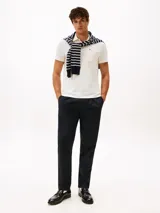 Chomba de manga corta en tejido jacquard elástico color blanco con textura de rayas horizontales. Presenta cuello clásico, tapeta con dos botones y un bolsillo de parche en el pecho con cierre de cremallera y logo bordado.