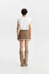 Top tipo musculosa de color blanco con cuello a la base y detalle estructurado en las sisas.