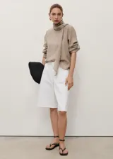 Short estilo jort de tiro medio, corte recto y confeccionado en tejido de algodón estilo denim. Cuenta con cierre de cremallera y botón, trabillas para cinturón y cuatro bolsillos.