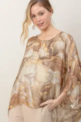 Blusa de seda estampada con diseño efecto marmolado en tonos marrones y beige, cuello redondo y mangas amplias tipo murciélago.