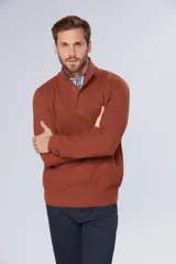 Buzo de tejido grueso color gris, con cuello alto y cierre frontal parcial. Presenta puños y ruedo acanalados, con un diseño de textura tejida en toda la prenda.