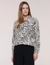 Camperita liviana de silueta entallada y largo a la cintura, con cuello camisero, cierre frontal de botones, mangas largas y bolsillos con solapa en el pecho. Presenta estampado animal print.