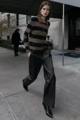 Chaqueta de punto con cuello polo y manga larga, diseño a rayas horizontales anchas en tonos marrón jaspeado y azul marino. Cierre frontal con botones pequeños forrados a tono.