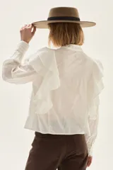 Blusa de algodón color blanco con volados frontales, cuello mao con lazos y detalles bordados en el pecho.