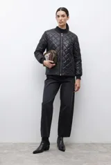 Campera bomber de diseño reversible, con acabado capitoneado en forma de rombos, cuello redondo, cierre frontal y puños elásticos.