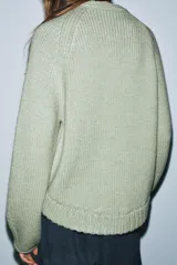 Jersey de punto grueso con cuello redondo, manga larga y diseño de bajo asimétrico.