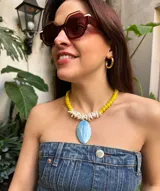 Collar corto de cristales amarillos y nácar blanco con dije de nácar celeste en forma ovalada.