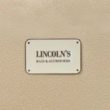 Billetera larga con cierre perimetral, confeccionada en material sintético texturizado color mostaza. Cuenta con correa de mano extraíble y placa metálica con logo de la marca en el frente.