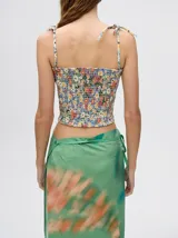 Top crop de tela denim con efecto fruncido, breteles finos ajustables con lazos y diseño entallado al cuerpo.