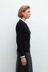 Cardigan negro de punto acanalado, con cuello redondo y cierre frontal de botones plateados.