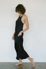 Vestido largo de estilo lencero confeccionado en viscosa, con cuello redondo, tirantes finos cruzados y detalle de nudo con abertura en la espalda.