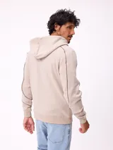 Canguro gris con capucha, cierre frontal completo y bolsillos tipo canguro. Presenta detalles de líneas blancas en las mangas y estampados gráficos en el pecho.