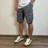 Bermuda cargo de gabardina en color beige, con bolsillos laterales tipo cargo con solapa y cierre de botón.