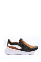 Zapatilla deportiva marrón de cuero liso con detalles en beige y plateado. Presenta cierre lateral y suela gruesa blanca.