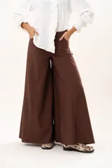 Pantalón de tiro medio con corte súper acampanado, confeccionado en gabardina con spandex. Presenta bolsillos delanteros y traseros, con cierre frontal de cremallera y botón.