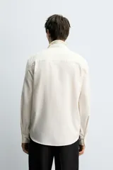 Camisa de corte regular fit confeccionada en una mezcla de algodón y lana. Presenta cuello solapa, manga larga con puños abotonados y cierre frontal con botonadura.