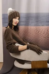 Gorro de punto degradé en tonos marrón y blanco, con diseño tejido en canalé y pompón superior claro.