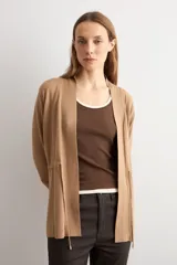 Ruana negra de tejido de punto, con mangas largas y cordón ajustable en la cintura.