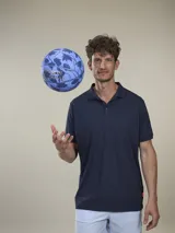 Polo de piqué azul marino, de corte clásico, con cuello abotonado y mangas cortas.