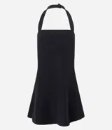 Vestido corto negro de crepé, sin mangas, con escote halter neck y recorte en el busto. La falda es ligeramente evasé y tiene cierre posterior con cremallera invisible.