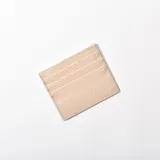 Tarjetero color beige con textura símil cuero de cocodrilo y múltiples ranuras para tarjetas.