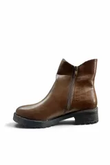 Botas cortas de cuero sintético color marrón, con suela track negra y detalle de textura símil cocodrilo en el lateral.