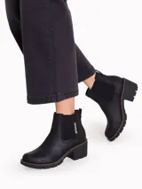Botines Chelsea para mujer de la marca Caterpillar, modelo Rewrite Chelsea, en color negro. Confeccionados en cuero liso con paneles laterales elásticos, detalle de la marca en vertical, taco cuadrado y suela dentada de goma.