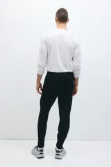 Pantalón deportivo de fútbol en color negro con tecnología DryMove, de corte ajustado, con cintura elástica con cordón ajustable, bolsillos laterales con cierre y cierres en los tobillos.