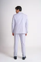 Ambo de dos piezas color gris claro, compuesto por un saco de corte clásico con solapas de muesca y un pantalón de vestir de corte recto con dobladillo en el ruedo.