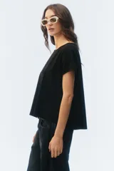 Remera negra de corte evasé y largo corto, con escote redondo y mangas cortas.