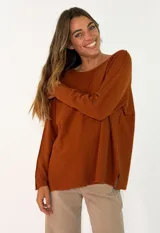 Sweater de punto color naranja, de corte holgado y diseño minimalista con cuello redondo y aberturas laterales en el ruedo.