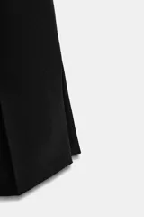 Pantalón de tiro alto con diseño cropped, confeccionado en tejido con viscosa. Presenta raya planchada frontal, aberturas laterales en el bajo y cierre lateral con cremallera oculta.