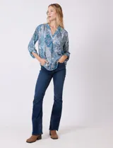 Blusa de gasa con estampado geométrico y paisley en tonos fucsia y blanco. Presenta cuello mao con escote en V, mangas tres cuartos con presilla y botón para regular el largo.