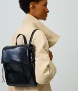 Mochila Satinato de poliuretano color negro, de diseño rectangular con solapa frontal, cierre magnético, bolsillos laterales con cierre y correas ajustables.