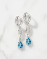 Caravanas colgantes de plata 925 con diseño de doble gota, una superior con pavé de circonias blancas y una inferior con una circonia central color celeste.