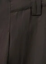 Pantalón de corte recto y tiro medio color marrón oscuro, confeccionado en lyocell, con detalle de pinzas delanteras, trabillas para cinto, bolsillos laterales y bolsillos de ribete en la parte posterior. Cierre frontal con botón y cremallera.