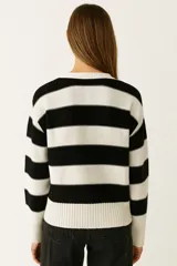 Cardigan de punto con cuello en V, manga larga y cierre frontal de botones. Presenta un diseño de rayas horizontales anchas en color beige y blanco crudo.