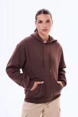 Buzo tipo canguro de felpa color marrón, con capucha ajustable mediante cordones y bolsillo frontal tipo canguro.