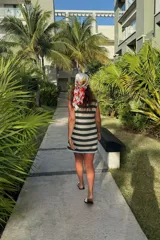 Vestido corto tejido a rayas horizontales en verde oscuro y beige, con cuello redondo y ribete celeste en el cuello y el dobladillo.