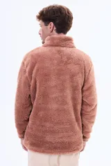 Buzo de sherpa de textura suave y cálida, con cuello alto y cierre frontal parcial. Presenta un diseño de manga larga y corte holgado.