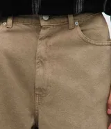 Pantalón masculino de corte barrel, confeccionado en sarga de algodón color beige. Presenta un diseño de piernas anchas con volumen en la cadera y leve entalle hacia el bajo, cintura con pasantes, cierre frontal con botón y bolsillos funcionales.