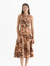 Vestido midi sin mangas con estampado de dragones en tonos marrones. Presenta cierre frontal con botones, falda amplia con gajos, recortes estilo jeanero, canesú y bolsillos laterales.