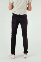 Pantalón de jean negro con diseño de roturas y efecto desgastado, corte ajustado y ruedo doblado.