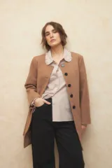 Tapado largo color crema, de paño, con cuello a la base y botones redondos veteados.