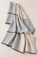 Bufandón de lana 100% lambswool, diseño de bloques en tonos gris, beige y líneas oscuras, con caída suave y ligera que permite usarlo también como ruana.