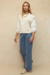 Pantalón de jean negro, ancho, de tiro alto y con dobladillo en las terminaciones.