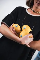 Vestido corto de tejido calado color marrón, con patrón cuadrado y logo bordado a mano en el frente. Presenta terminaciones a contratono en escote redondo y mangas cortas.