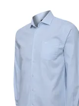 Camisa de manga larga de algodón celeste con sutil patrón a cuadros, cuello camisero, cierre frontal con botones y un bolsillo en el pecho con logo bordado.