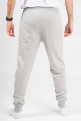 Pantalón de jogging unisex de felpa, color verde oscuro, con cintura elástica con cordón de ajuste y puños elásticos en los tobillos.