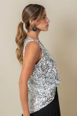 Blusa sin mangas confeccionada en tela cubierta de lentejuelas doradas y plateadas, con escote redondo y corte holgado.